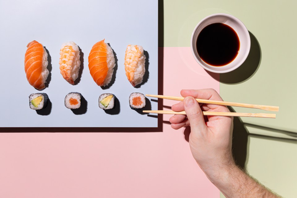 Sushi-Motiv mit Hand und Essstäbchen