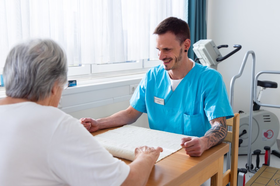 Therapeut im Gespräch mit einer Patientin der Akutgeriatrie